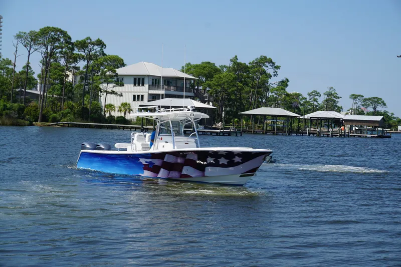 Slide: The Image of 2012 Regulator 32 Forward Seating boat with American flag design on water. - 46