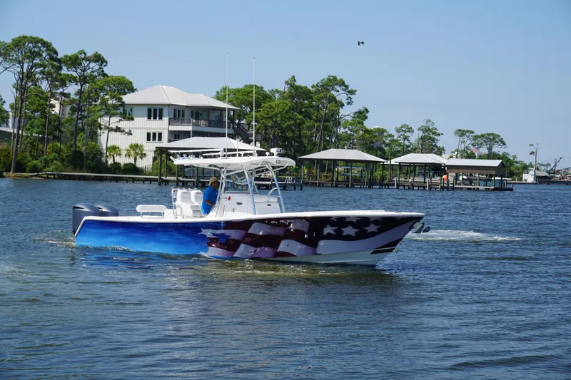 Slide: The Image of 2012 Regulator 32 Forward Seating boat with American flag design on a calm lake. - 47