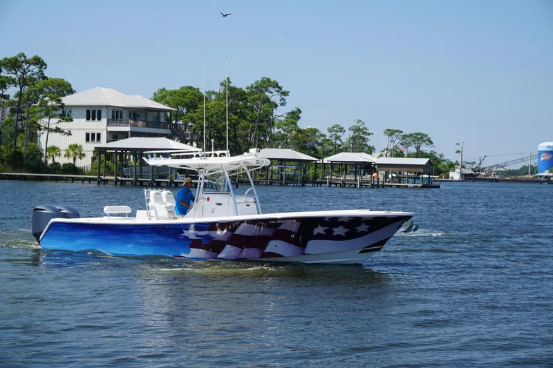 Slide: The Image of 2012 Regulator 32 Forward Seating boat with American flag design on water. - 48