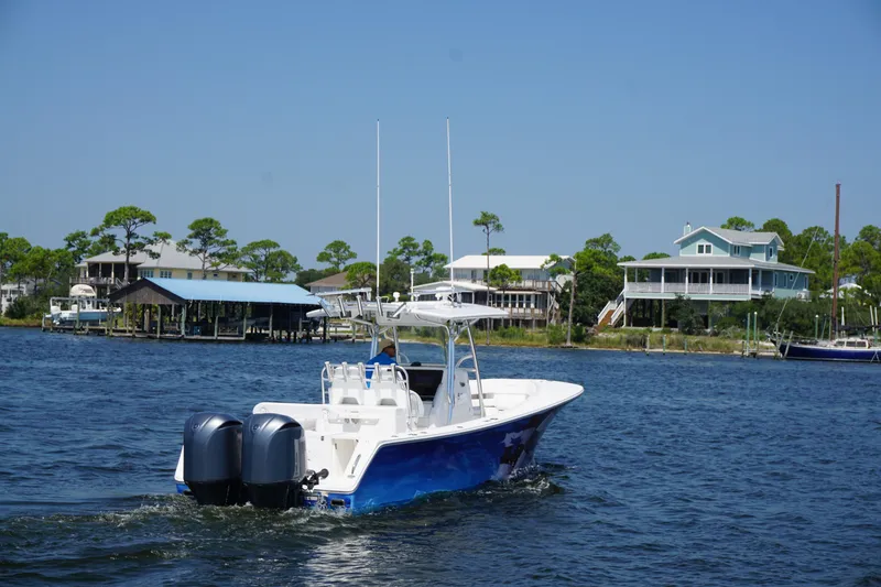 Slide: The Image of 2012 Regulator 32 Forward Seating boat cruising near waterfront homes. - 49