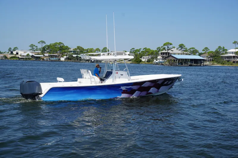 Slide: The Image of 2012 Regulator 32 Forward Seating boat cruising on a sunny day near waterfront homes. - 50