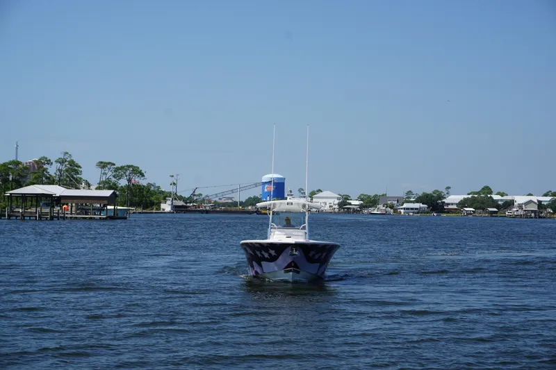 Slide: The Image of 2012 Regulator 32 Forward Seating boat cruising on a calm river under clear blue skies. - 52