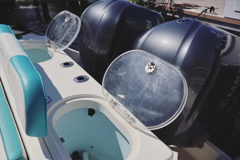 Slide: The Image of 2015 Cobia 29’6 boat with Yamaha engines and open storage compartments. - 10