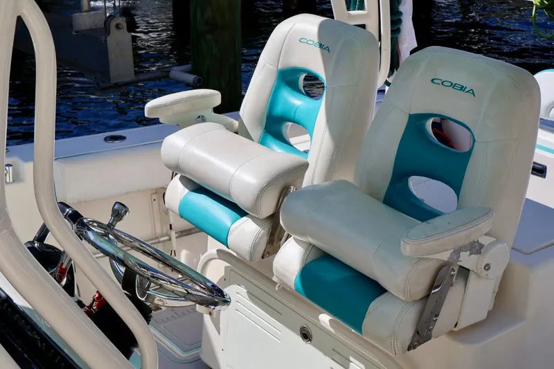 Slide: The Image of 2015 Cobia 29’6 boat with dual white and teal captain chairs. - 4