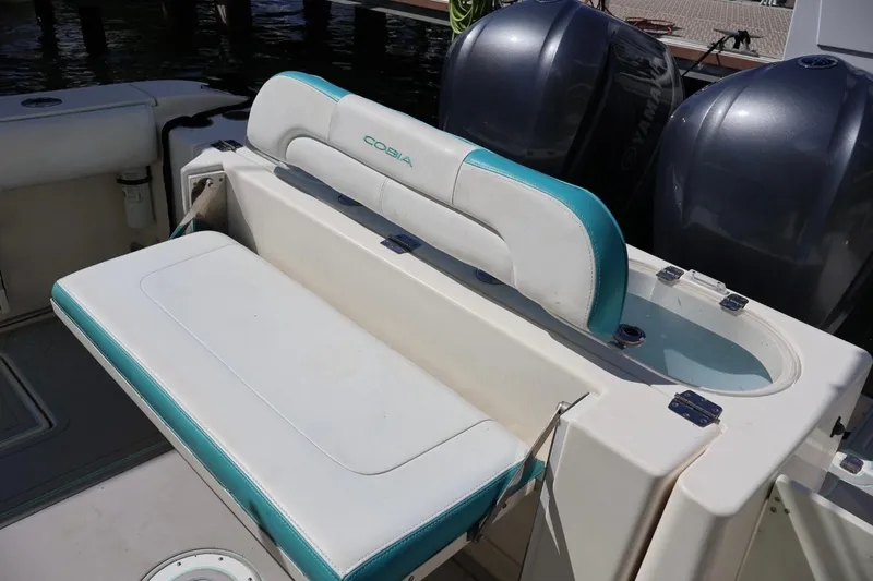Slide: The Image of 2015 Cobia 29’6 boat with cushioned seating and dual Yamaha engines. - 5
