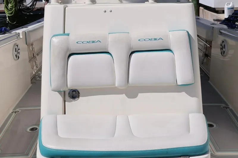 Slide: The Image of 2015 Cobia 29’6 boat seating with white and teal cushions. - 6