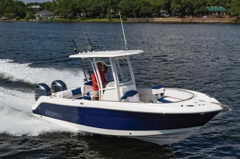 Slide: The Image of 2019 Robalo R242 Center Console boat cruising on a lake with two passengers. - 32