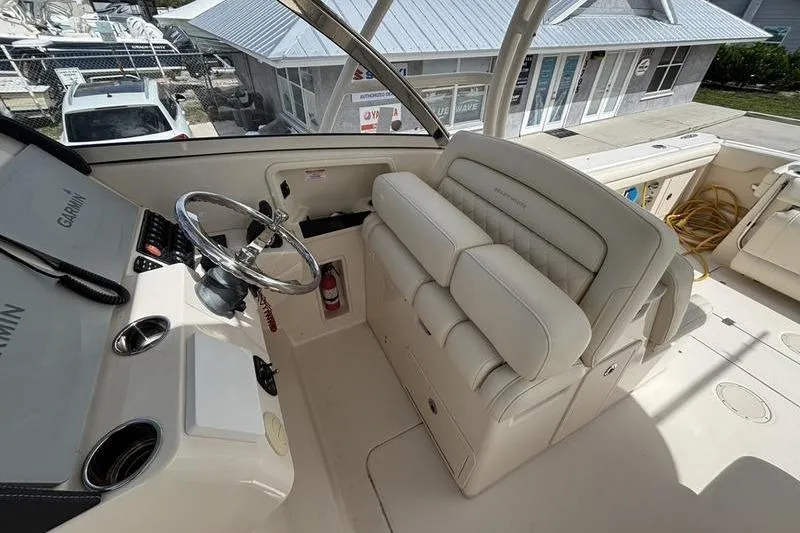 Slide: The Image of Helm of 2018 Grady-White Freedom 325 boat with steering wheel and seating. - 12