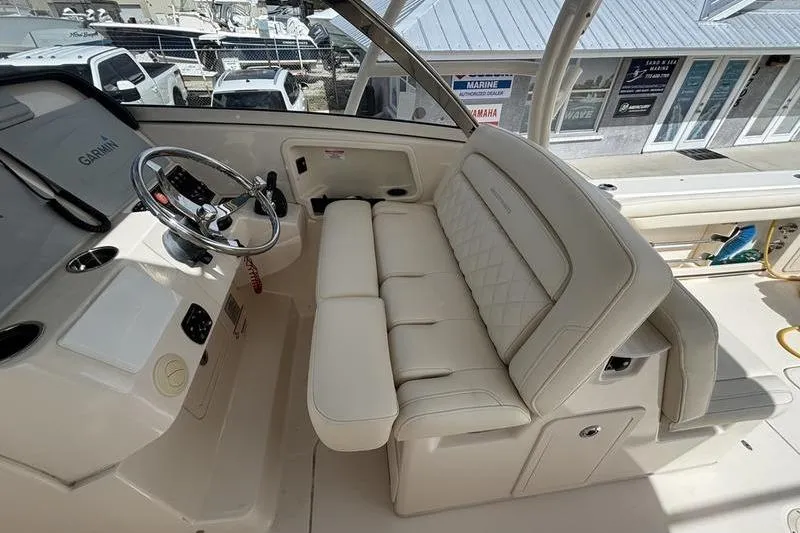 Slide: The Image of 2018 Grady-White Freedom 325 boat interior with steering wheel and cushioned seating. - 13