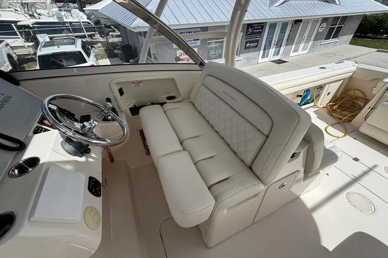 Slide: The Image of 2018 Grady-White Freedom 325 boat interior with steering wheel and cushioned seating. - 15