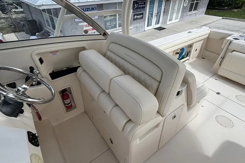 Slide: The Image of 2018 Grady-White Freedom 325 boat interior with steering wheel and cushioned seating. - 16