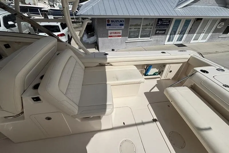 Slide: The Image of 2018 Grady-White Freedom 325 boat interior with beige seating and marine dealership background. - 27