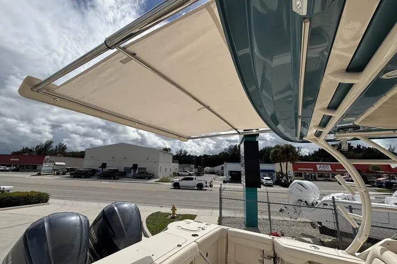 Slide: The Image of 2018 Grady-White Freedom 325 boat with dual engines and retractable canopy, parked near a dealership. - 28