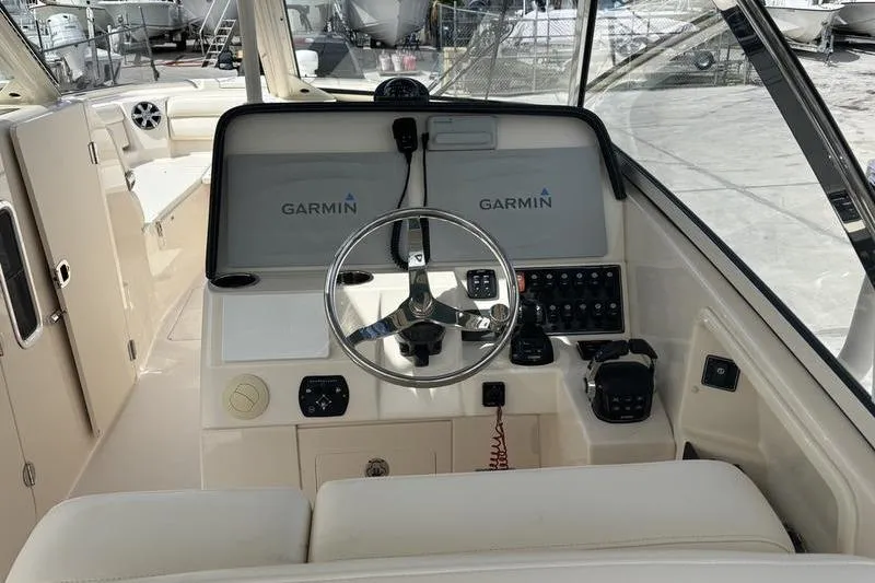 Slide: The Image of 2018 Grady-White Freedom 325 boat helm with Garmin navigation system and steering wheel. - 29