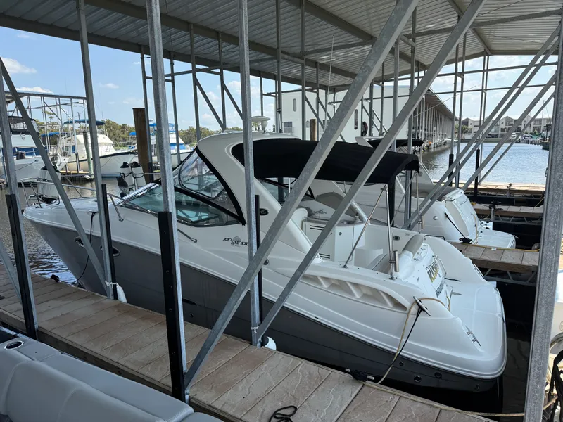 The Image of 2007 Sea Ray 290 Sundancer docked in a marina under a covered slip. - 0