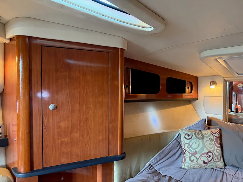 Slide: The Image of Interior of 2007 Sea Ray 290 Sundancer with wood cabinetry and cozy bedding. - 4