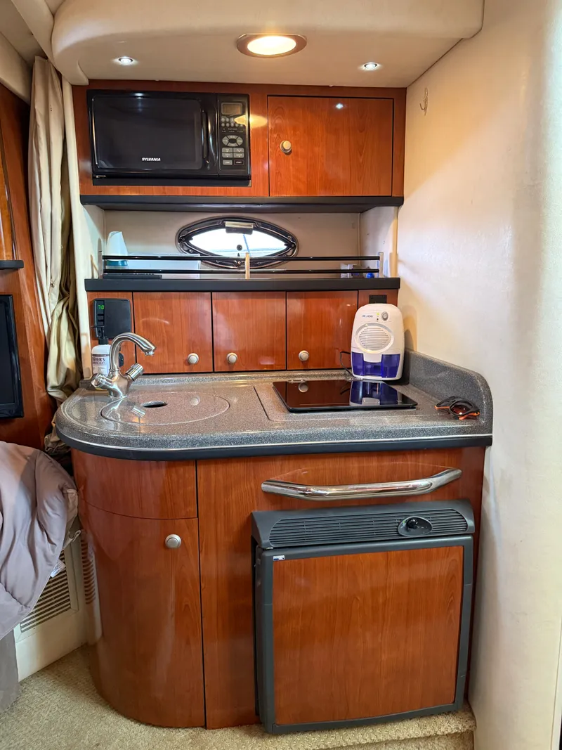 Slide: The Image of 2007 Sea Ray 290 Sundancer galley with microwave, sink, and compact fridge. - 7