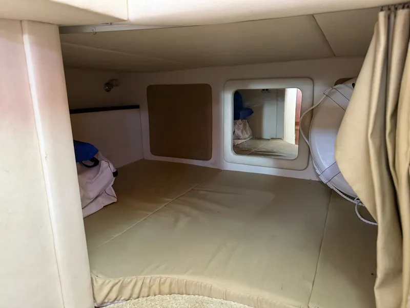 Slide: The Image of 2007 Sea Ray 290 Sundancer cabin interior with beige cushions and storage space. - 9