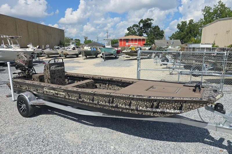 Slide: The Image of 2026 Pro-Drive 2054 X Series TD boat on trailer, parked in a boatyard under a cloudy sky. - 5