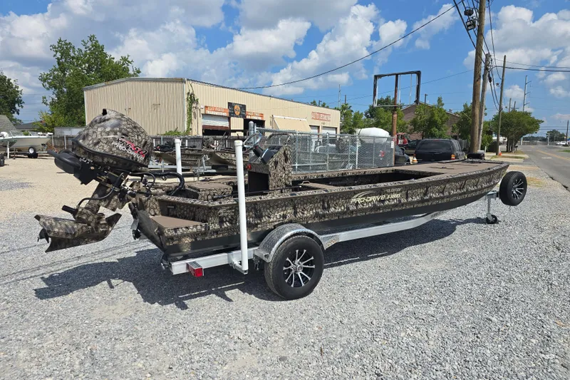 Slide: The Image of 2026 Pro-Drive 2054 X Series TD boat on trailer, camo design, outdoor setting. - 6