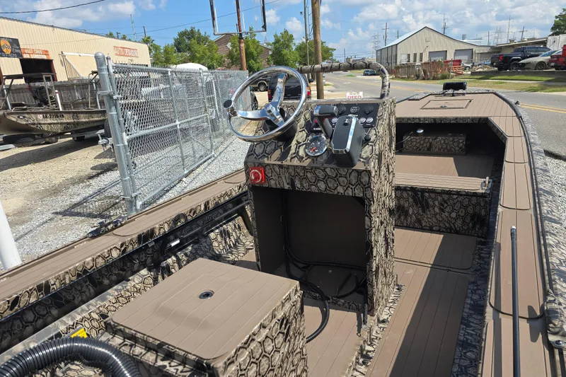 Slide: The Image of 2026 Pro-Drive 2054 X Series TD boat with camouflage design, parked outdoors. - 8