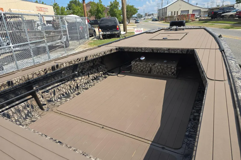 Slide: The Image of 2026 Pro-Drive 2054 X Series TD boat with camouflage interior, parked near auto repair shop. - 9