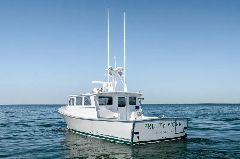 Slide: The Image of 2025 Mussel Ridge 42 boat named "Pretty Work" on calm ocean waters. - 10