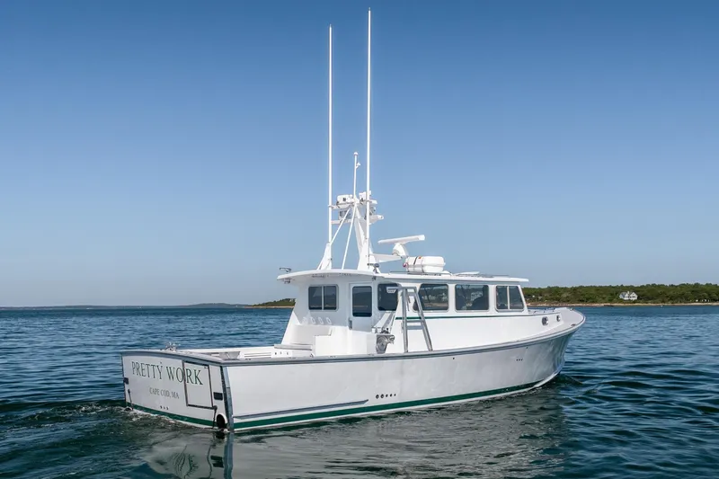 Slide: The Image of 2025 Mussel Ridge 42 boat on calm water, clear sky background. - 14