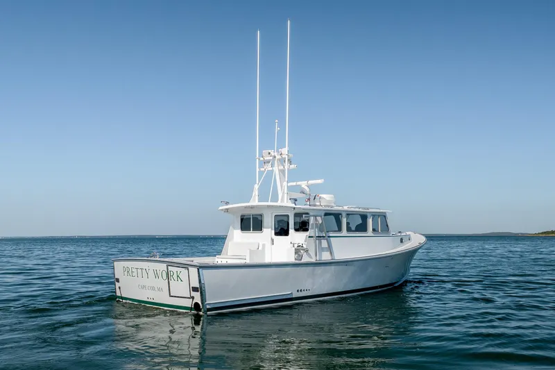 Slide: The Image of Mussel Ridge 42 boat, 2025 model, on calm ocean waters under clear blue sky. - 15