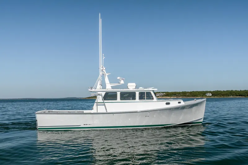 Slide: The Image of 2025 Mussel Ridge 42 boat on calm water under clear blue sky. - 16