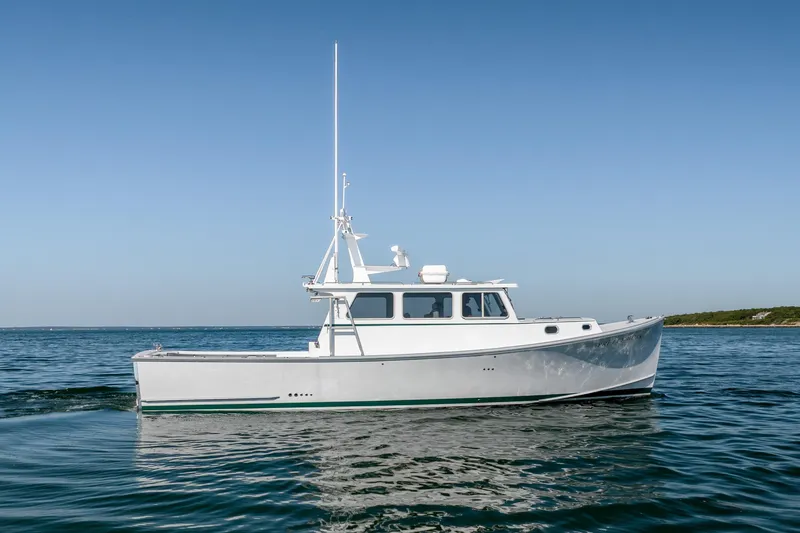 Slide: The Image of 2025 Mussel Ridge 42 boat cruising on calm blue waters under clear sky. - 17