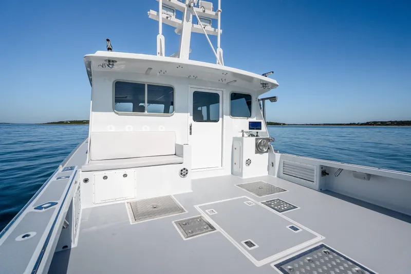 Slide: The Image of 2025 Mussel Ridge 42 boat deck with seating, cruising on calm blue waters. - 19