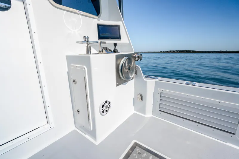 Slide: The Image of 2025 Mussel Ridge 42 boat interior with control panel, overlooking calm blue waters. - 21