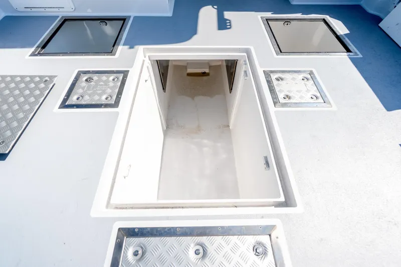 Slide: The Image of Mussel Ridge 42 boat deck with open hatch, showcasing storage compartments, 2025 model. - 28