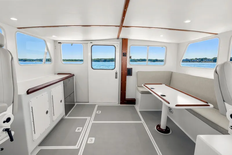 Slide: The Image of Interior of 2025 Mussel Ridge 42 boat, featuring modern seating and panoramic windows. - 34