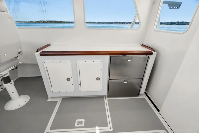 Slide: The Image of Interior of 2025 Mussel Ridge 42 boat with cabinets and scenic window view. - 35