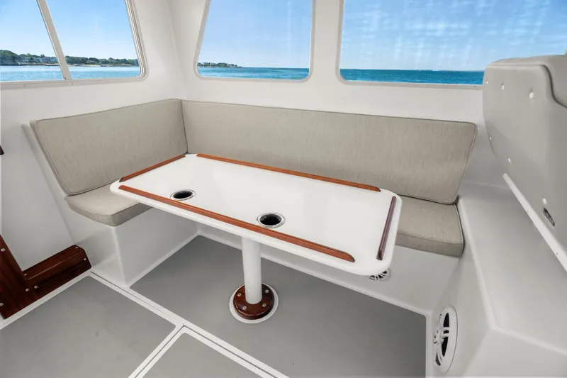 Slide: The Image of Interior of 2025 Mussel Ridge 42 boat with cushioned seating and table, ocean view. - 36