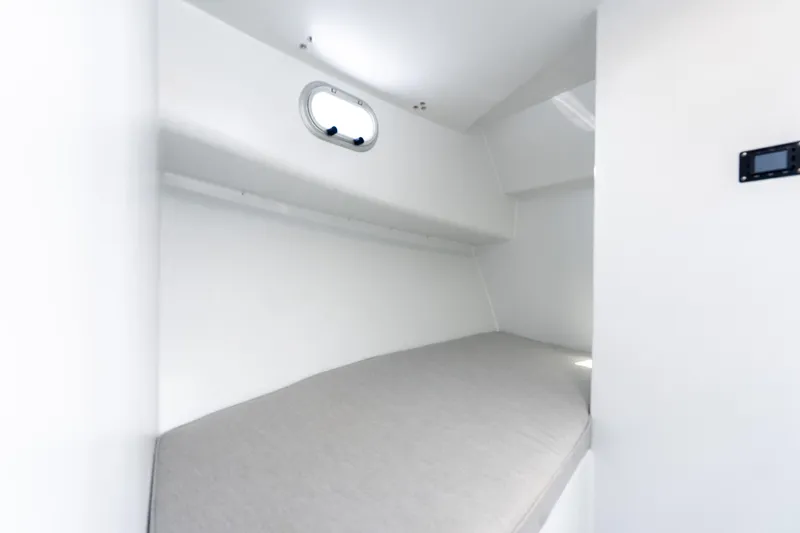 Slide: The Image of 2025 Mussel Ridge 42 boat interior cabin with a single bed and porthole window. - 47