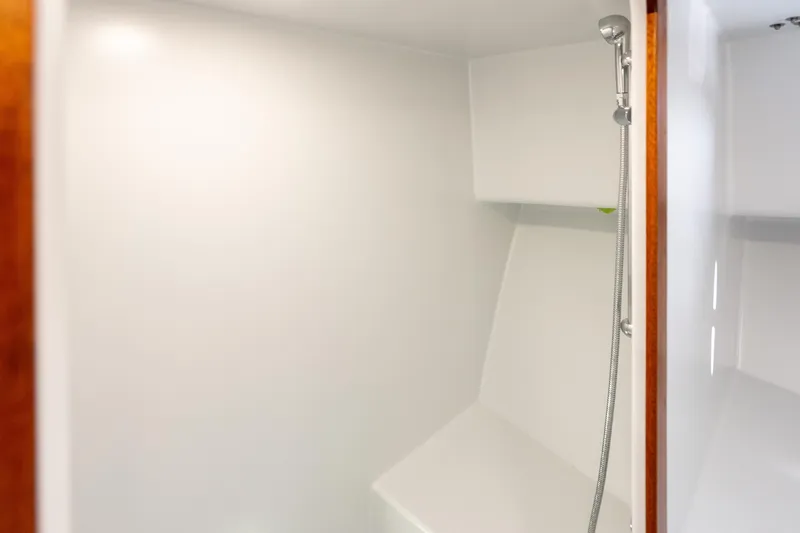 Slide: The Image of 2025 Mussel Ridge 42 boat interior shower with sleek white design and modern fixtures. - 49