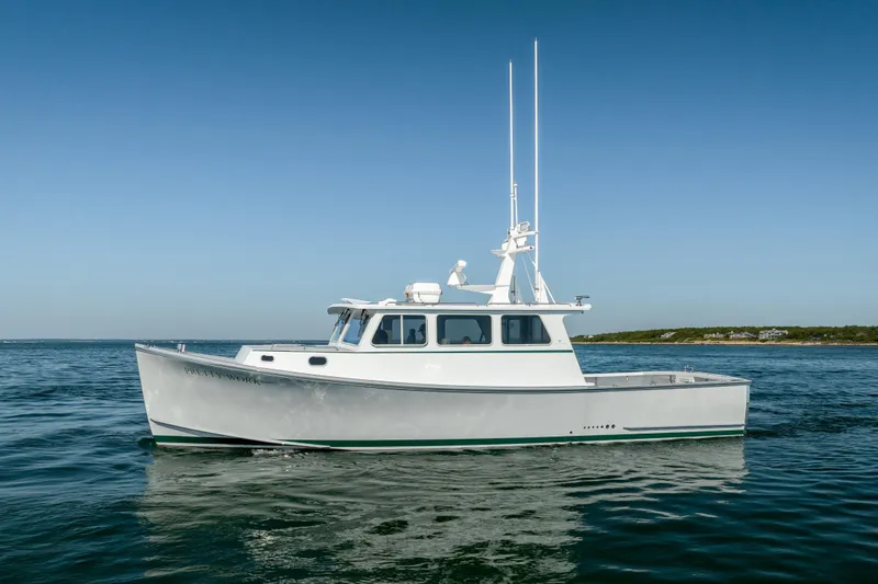 Slide: The Image of 2025 Mussel Ridge 42 boat on calm ocean waters under clear blue sky. - 7