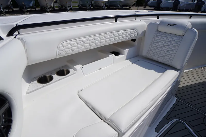 Slide: The Image of 2026 Tidewater 302 CC Adventure boat interior with white cushioned seating and cup holders. - 10