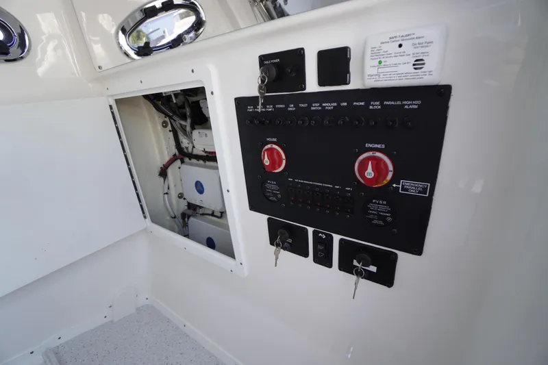 Slide: The Image of Control panel of 2026 Tidewater 302 CC Adventure boat, featuring switches and keys. - 33