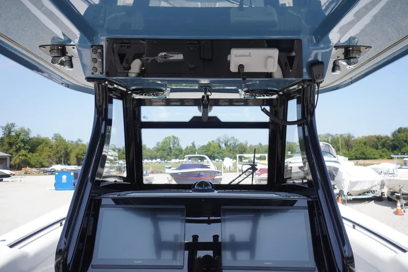 Slide: The Image of 2026 Tidewater 302 CC Adventure boat dashboard with dual Garmin screens and overhead electronics. - 42