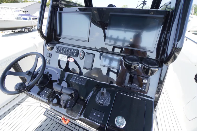 Slide: The Image of 2026 Tidewater 302 CC Adventure boat dashboard with dual screens and steering wheel. - 47
