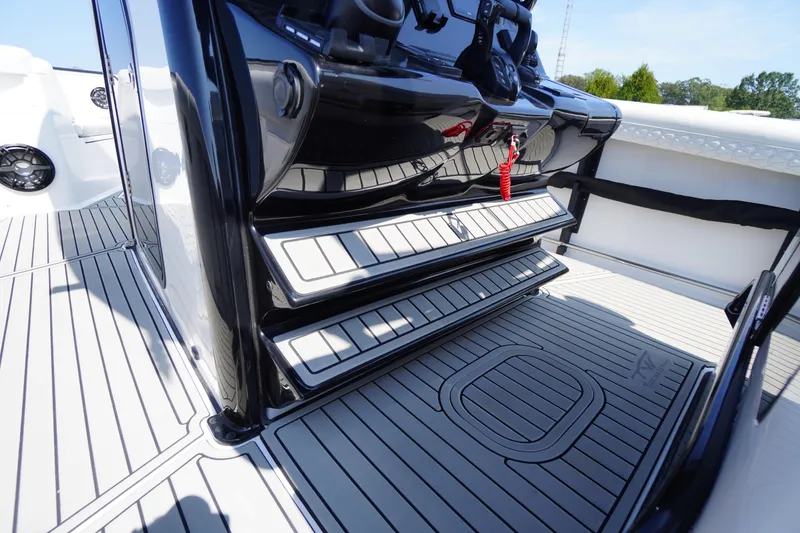 Slide: The Image of 2026 Tidewater 302 CC Adventure boat interior with sleek black console and striped flooring. - 49