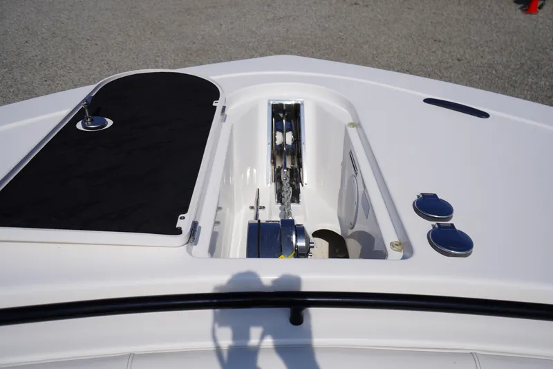 Slide: The Image of 2026 Tidewater 302 CC Adventure boat anchor compartment with open hatch and chain mechanism. - 6