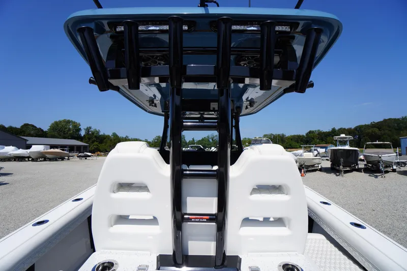 Slide: The Image of 2026 Tidewater 302 CC Adventure boat interior with seating and rod holders, parked outdoors. - 70