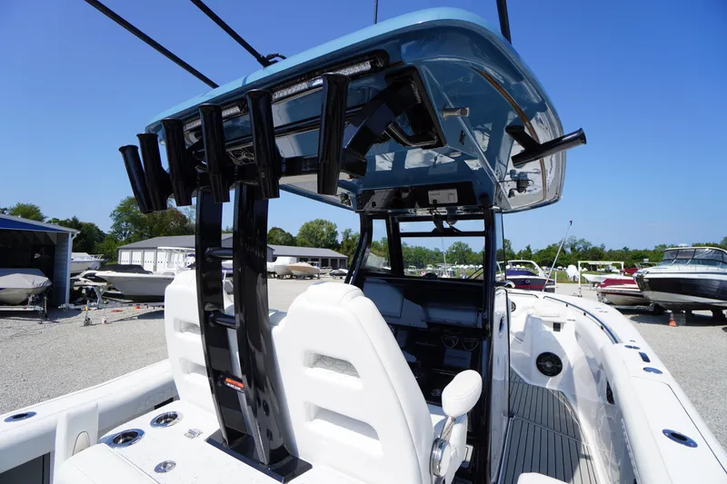 Slide: The Image of 2026 Tidewater 302 CC Adventure boat interior with rod holders and console, docked outdoors. - 71