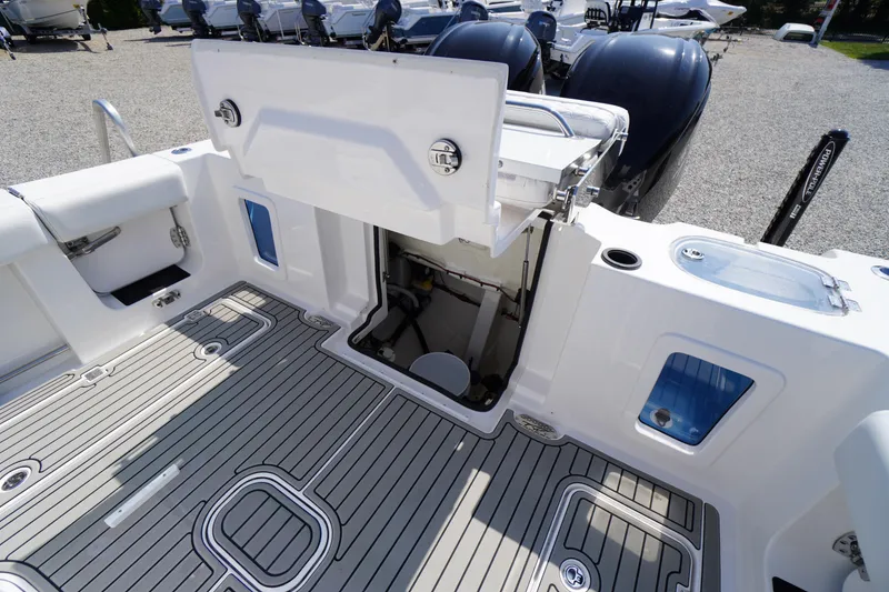 Slide: The Image of 2026 Tidewater 302 CC Adventure boat deck with open storage compartment and sleek design. - 79