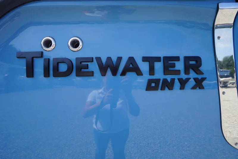 Slide: The Image of 2026 Tidewater 302 CC Adventure boat with Onyx branding on blue hull. - 88